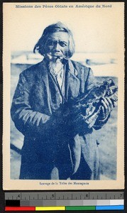 Man with pipe holding a bundle of furs, Canada, ca.1920-1940