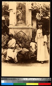 Woman and children with a missionary by a statue of Christ, India, ca.1920-1940