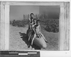 Boys playing on a tank at Wuzhou, China, 1947