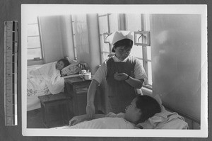 Nurse checking on patient, Jinan, Shandong, China, 1941