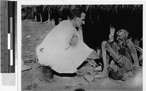 Priest kneeling by a sick man, Africa, 1939