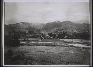 Junon town and the surrounding country. Bare mountains. In the foreground rice fields and the river