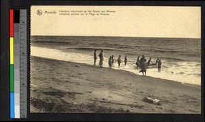 Men pushing a small boat out from a beach, Congo, ca.1922