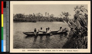 Missionary father sitting behind paddlemen in a canoe, Madagascar, ca.1920-1940