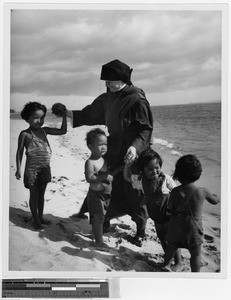 Sister Adrienne Mundy, MM, with some children on Kihei Beach, Hawaii, 1944