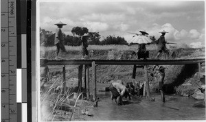 Four people crossing a bridge, Wuchow, China, 1930