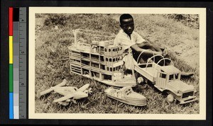 Child sitting with wooden toys, Congo, ca.1920-1940