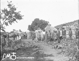 Group of African people standing in front of huts, Pretoria, South Africa, ca. 1896-1911