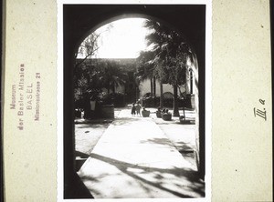 Courtyard in Honyen. In the background mission house and church. On the left the well, 10 m. deep