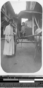 Sr. Celeste, MM, standing next to a horse-drawn carriage in front of St. Paul's Hospital, Manila, Philippines, ca. 1930