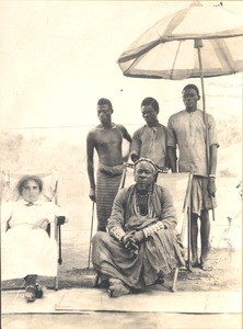 Female missionary seated under parasol with African Chief, Zambia, ca.1917