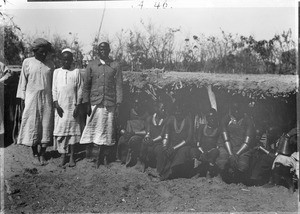 Africans in front of low hut, Tanzania, ca.1893-1920