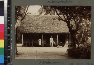 Missionary and wife outside small thatched mission house, Madagascar, ca. 1900