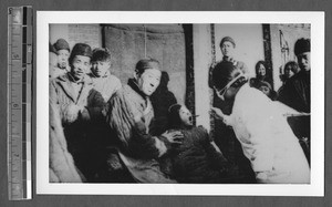 Feeding a child cod liver oil, Jinan, Shandong, China, ca.1940