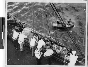 Peddlers selling from their boats to passengers on a larger ship, Hong Kong, China, 1947