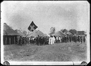 Swiss missionaries and African people in front of buildings with thatched roofs, southern Africa, ca. 1880-1914