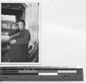 Elderly woman holding child at Xinbin, China, 1935