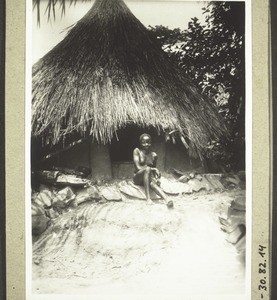 A Djale woman in front of her house (1928). As adornment she has stuck porcupine spines through her nose