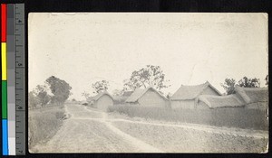 Village buildings standing beside a roadway, China, ca.1904