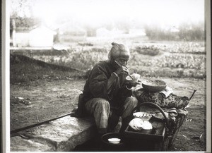 An old woman stops by the wayside for her midday meal. When someone tried to take a picture of her, she said: 'But in what way am I beautiful to look at?