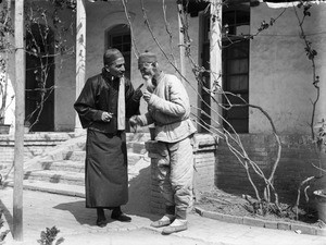 Fr. Anthony Cotta, MM, talking to an elderly man, China, ca. 1906-1919
