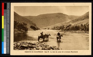 Two men crossing a shallow river on horseback, South Africa, ca.1920-1940