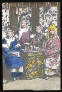 Four richly-adorned women sitting around a small square table, China, ca.1917-1923