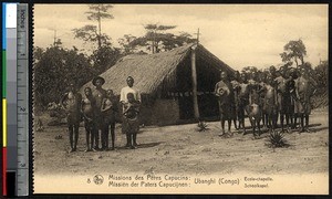 Indigenous men and women in front of a thatched-roof chapel, Congo, ca.1900-1930