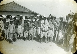 The men wear traditional dress, with caps or turbans on their heads