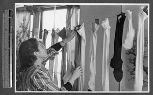 Woman filling Christmas stockings, Jinan, Shandong, China, 1941