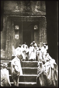 Priester u. Mönche vor e. Felsenkirche = Lalibela