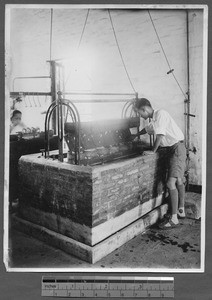 Student using cocoon boiling machine, Guangzhou, Guangdong, China, 1931