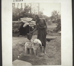 "A collection-box for offerings (in front of the temple). India."