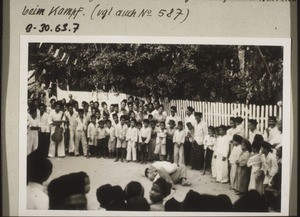 Phases of the mock-battle on the street which takes place before the bridegroom is allowed to go up into the house. Two boys wrestling