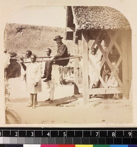 Outdoor portrait of FFMA missionary, Henry E. Clark leaving house by filanjana, Madagascar, ca. 1865-1885