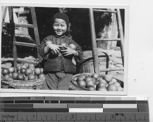 A child holding fruit at Guilin, China, 1936