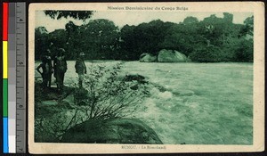 Men standing beside a fast-flowing river, Congo, ca.1920-1940