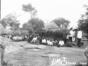 Swiss missionaries and African people in front of a hut, Antioka, Mozambique, ca. 1896-1911