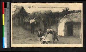 Missionary father looking into a hut while others stand outside, Congo, ca.1920-1940