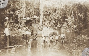 Head porterage, crossing stream, Nigeria, ca. 1924