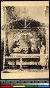 Boy standing with clasped hands before a Christmas creche, Congo, ca.1920-1940