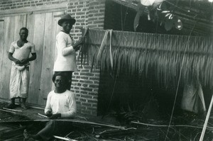 Men making roofs, in Oyem, Gabon