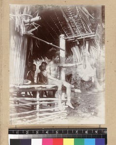 Man with baby in cradle bag, Delena, Papua New Guinea, ca. 1905-1915