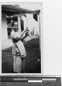 A girl hanging out laundry the orphanage at Luoding, China, 1936