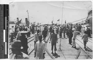 People gathered on wharf greeting passengers, Hong Kong, China, ca.1920