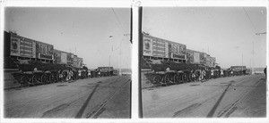 Durban : row of rickchaws along a street; advertising posters in the background