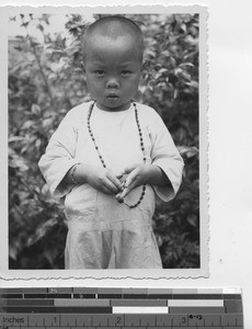 A young boy wearing rosary beads in China, 1945