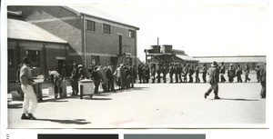 Men receiving food in a workers' compound, South Africa