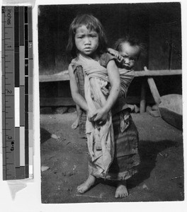 Girl carrying her baby brother on her back Philippines, ca. 1920-1940