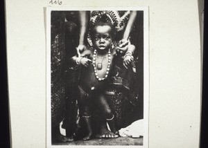 Child with ornaments and an amulet on its chest